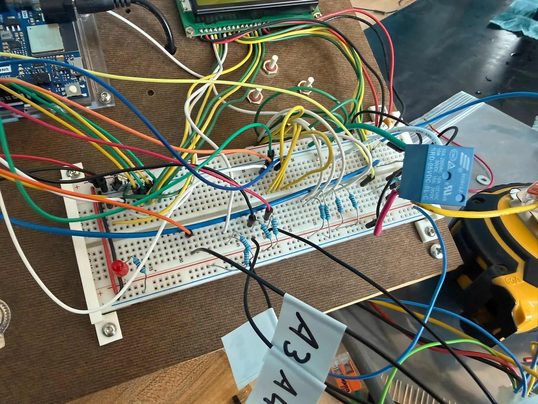 The working circuit on a breadboard, wired to the Arduino, screen, and relay