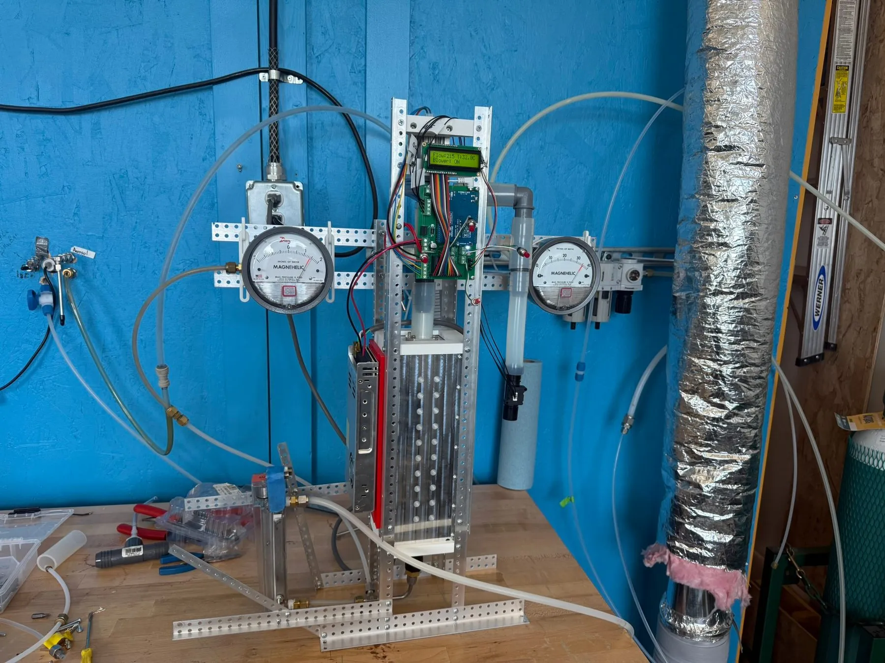 The characterization setup: the impactor and controller mounted on a frame between two pressure gauges