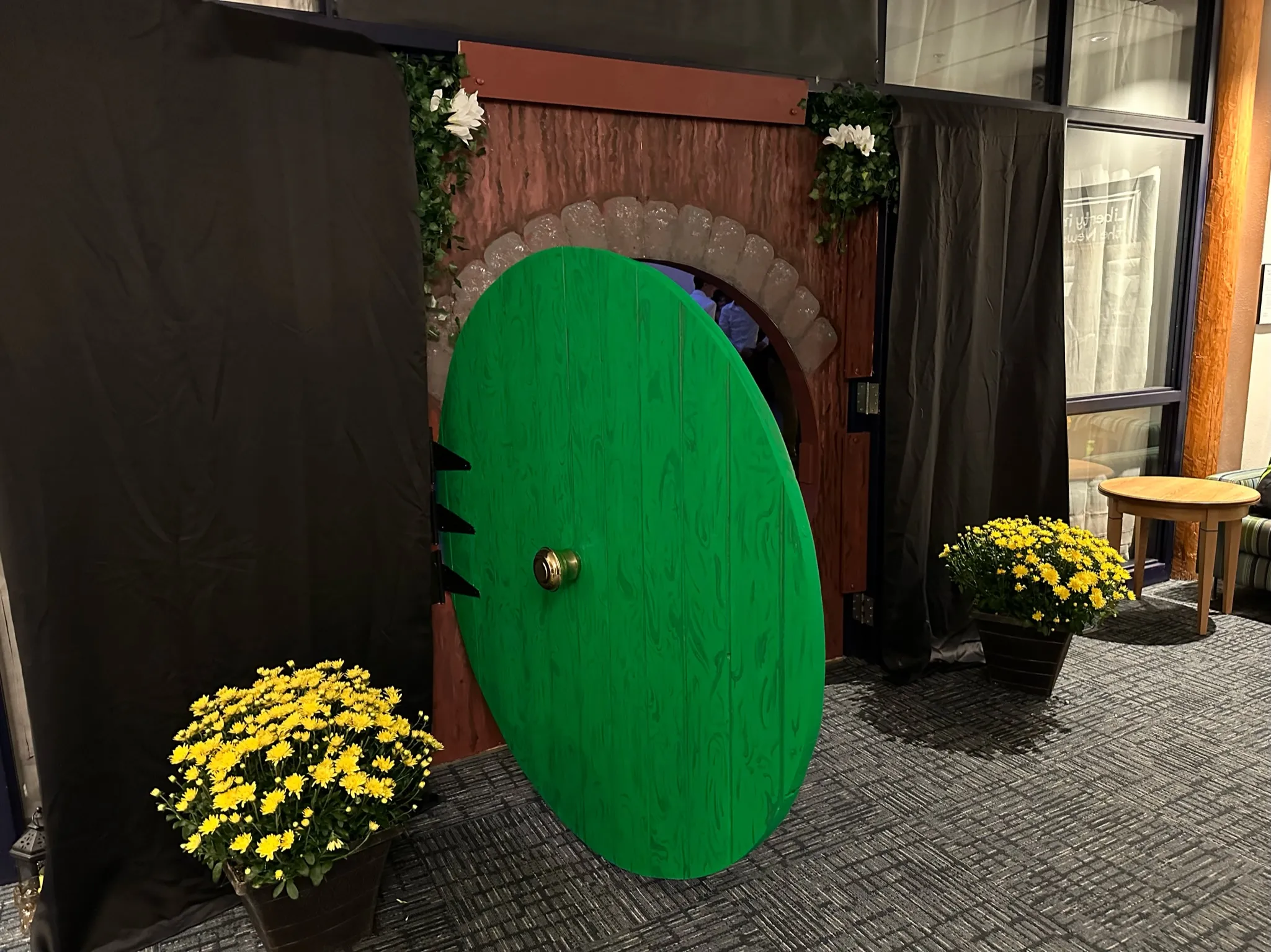 The finished green round Hobbit door installed in its stone-arch surround