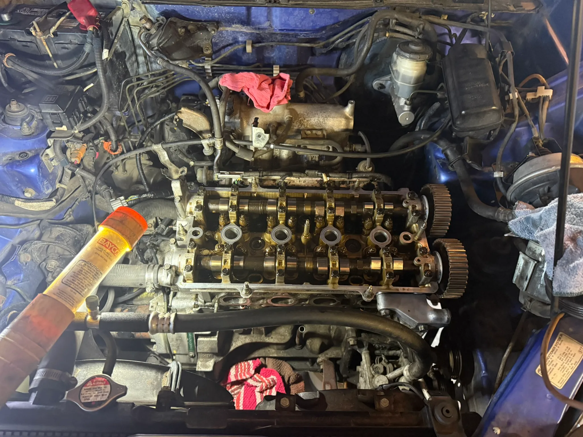 Engine bay with the valve cover removed, camshafts and timing components exposed