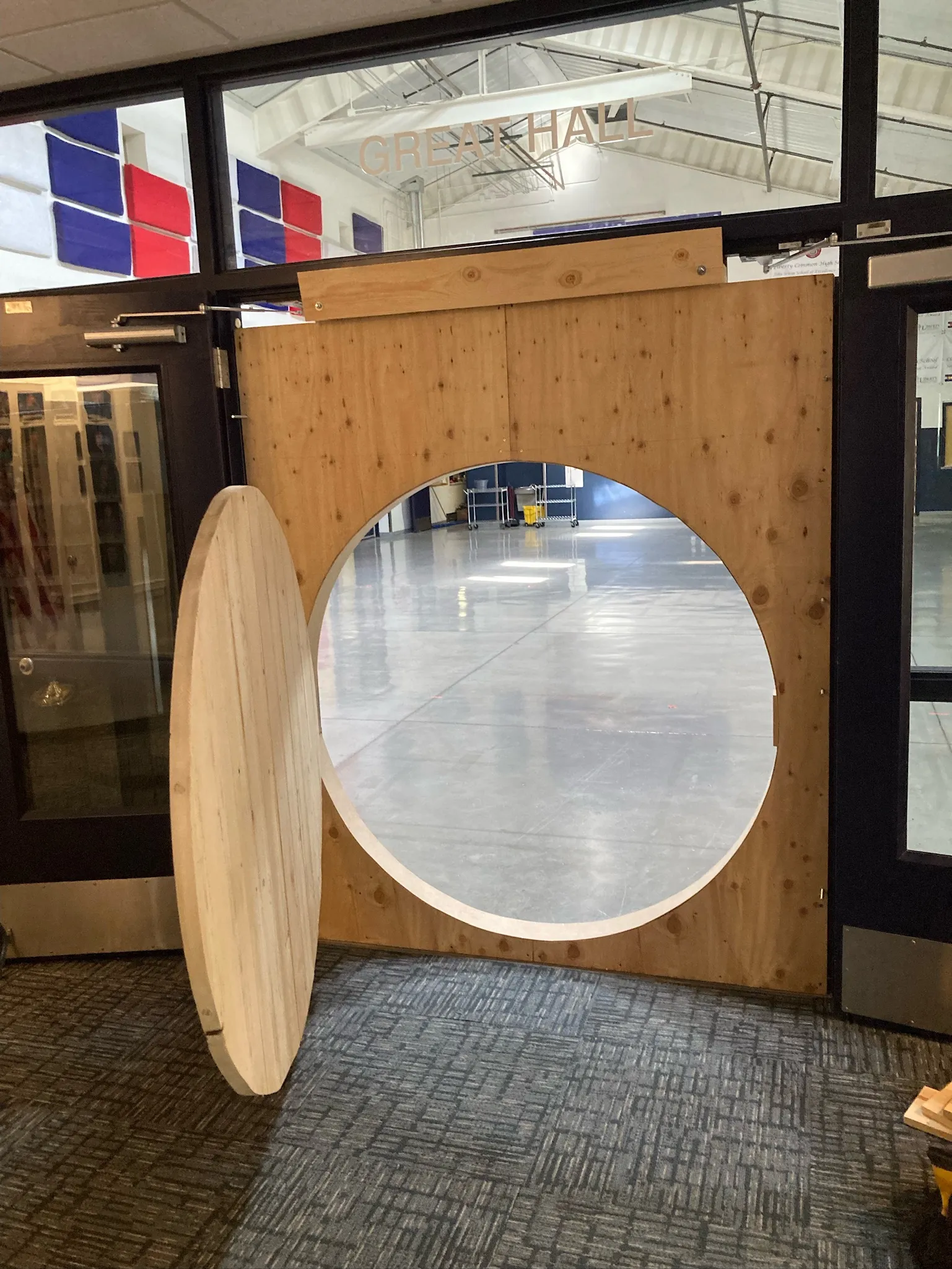 The bare wood round door hung in its opening, standing open