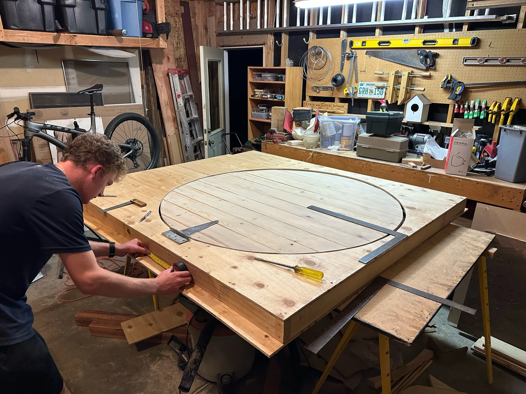 Marking out the circle across an assembled plank panel in the shop