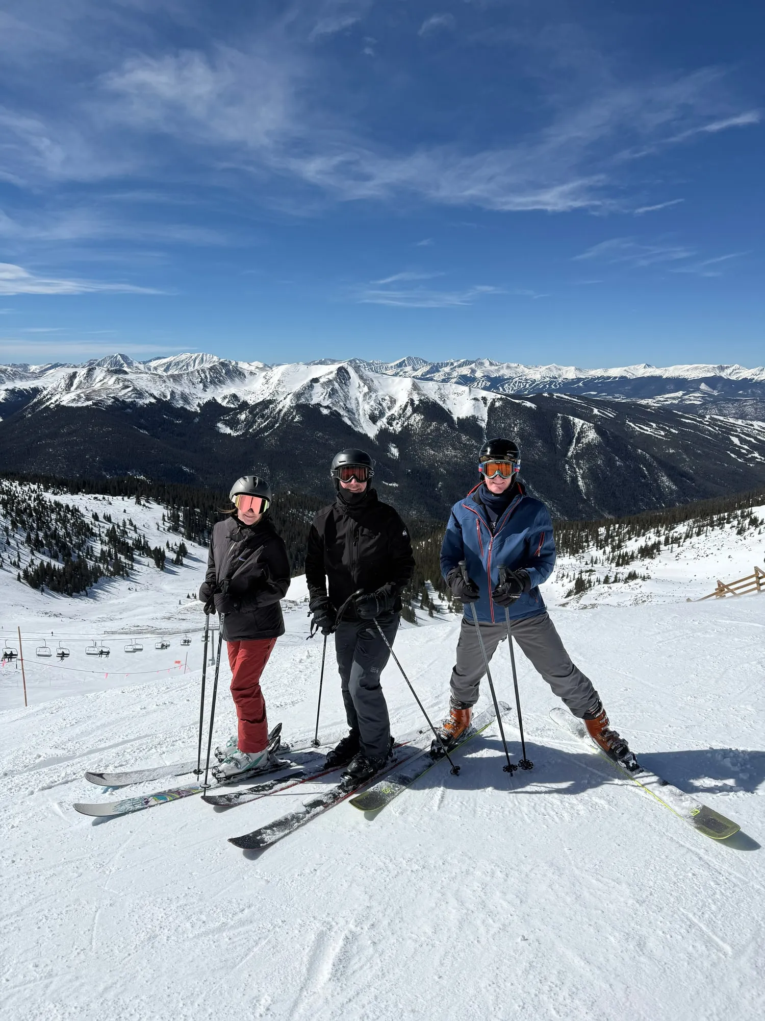 Skiing high above a valley, with the snow-covered Rockies behind